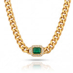 Gold chain necklace with a green gemstone and clear stones on a white background