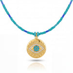 Necklace with gold pendant and turquoise beads on a white background