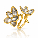 A two-tone gold and silver flower ring with small yellow gemstone accents, displayed on a clean white background with a soft reflection below.