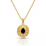Gold necklace with a round pendant featuring a black stone on a white background