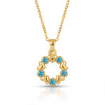 Gold necklace with a circular pendant featuring blue gemstones on a white background