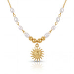 Necklace with gold sun pendant and pearl beads on a white background