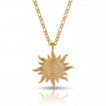 Gold sun-shaped pendant necklace on a white background