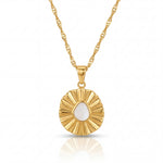 Gold necklace with a circular pendant on a white background