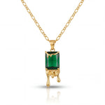 Gold necklace with a green gemstone pendant on a white background