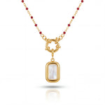 Gold necklace with a pendant featuring a white stone on a white background