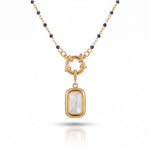 Gold necklace with a pendant featuring a white stone on a white background