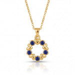 Gold necklace with a circular pendant featuring blue stones on a white background