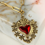 Zoomed-in shot of ornate Sacred Heart pendant with dove and flower details.