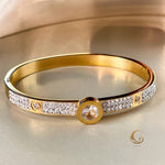 Gold bracelet on a satin background, showcasing sparkle and refined crystal details with central round zirconia centerpiece.