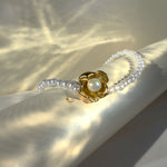 Gold flower pendant pearl necklace with soft light reflections