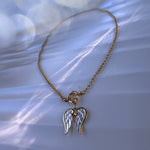 Necklace with angel wing pendant on a soft white background