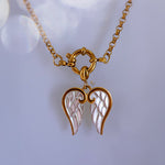 Gold necklace with angel wing pendant on a light background