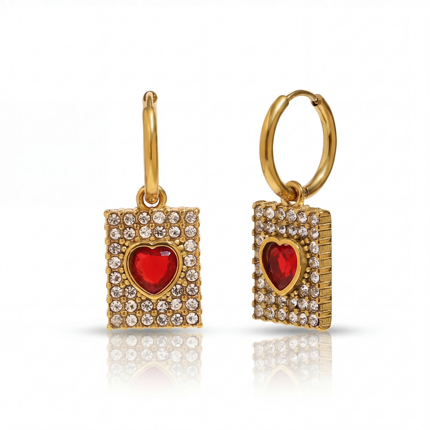 Gold hoop earrings with red heart and clear stones on a white background