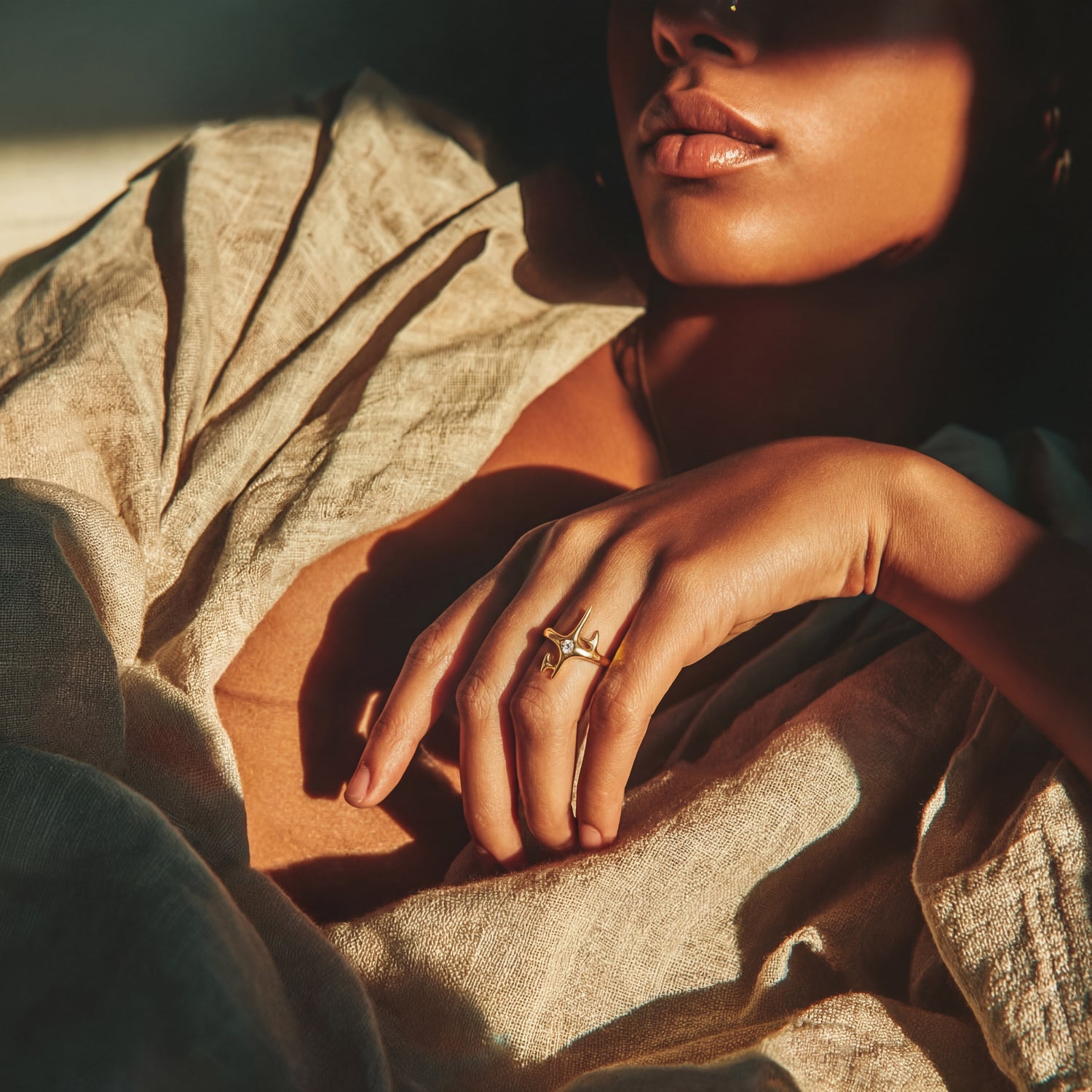 Close-up of a person's hand with a ring on a textured surface