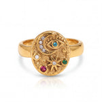 Gold ring with celestial design and colorful gemstones on a white background