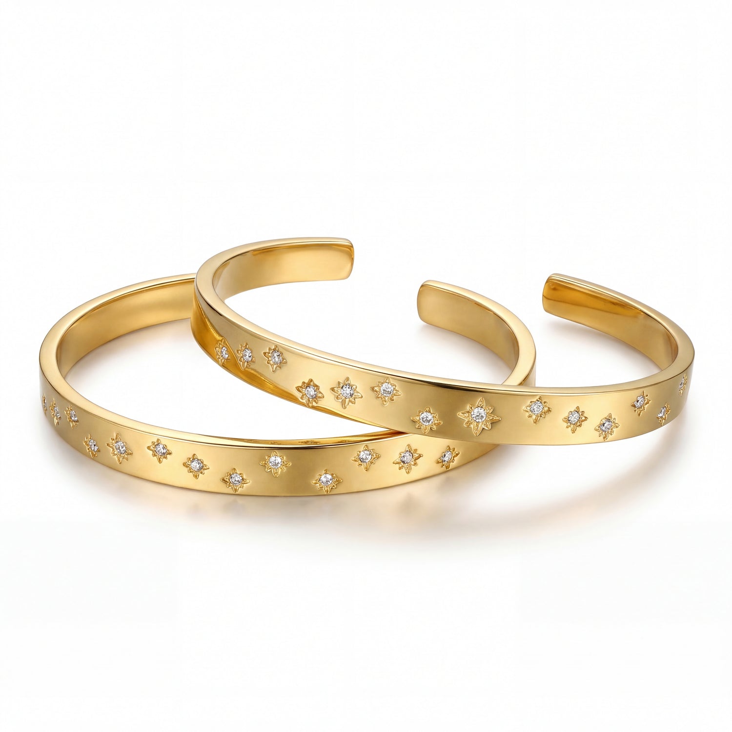 Two gold bangles with star-shaped embellishments on a white background