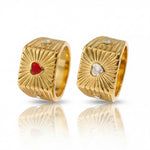 Gold hoop earrings with red and clear gemstones on a white background