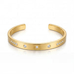 Gold bracelet with embedded stones on a white background