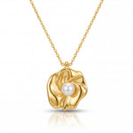 Gold necklace with a floral pendant featuring a pearl on a white background