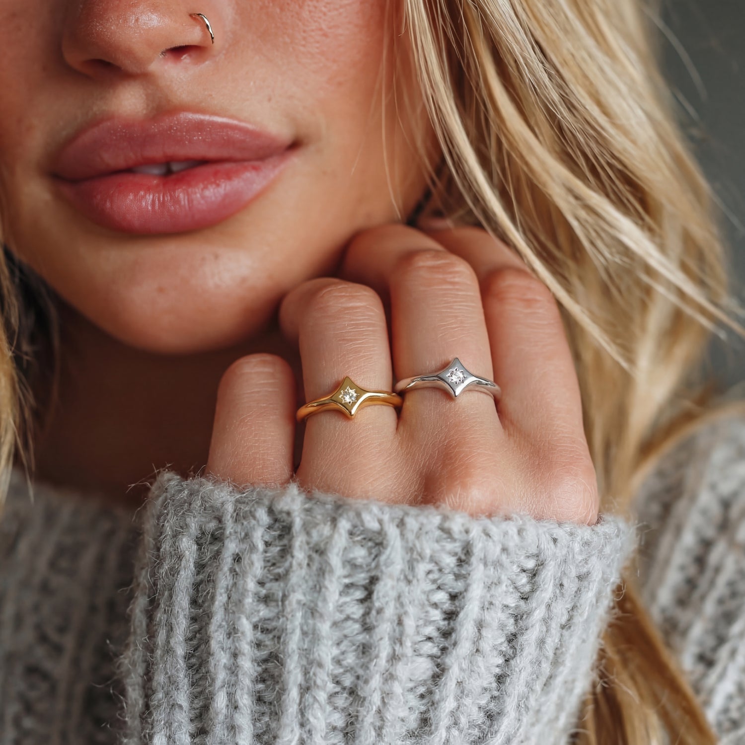 Close-up of a woman's hand wearing two rings with a blurred background