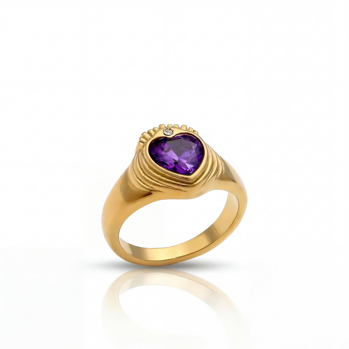 Gold ring with a heart-shaped purple gemstone on a white background