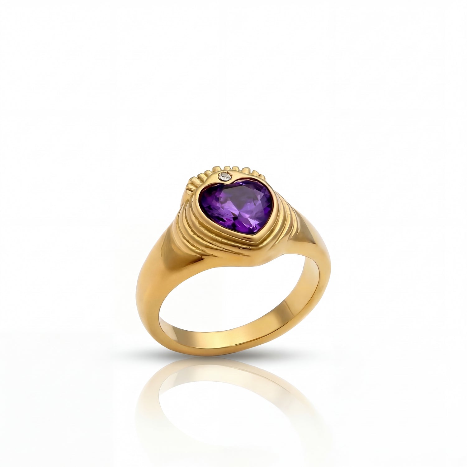 Gold ring with a heart-shaped purple gemstone on a white background