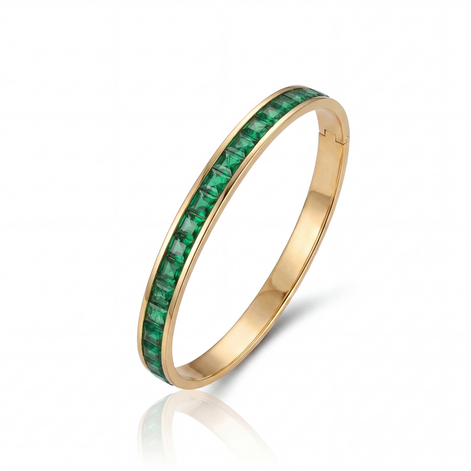 Gold ring with green gemstones on a white background