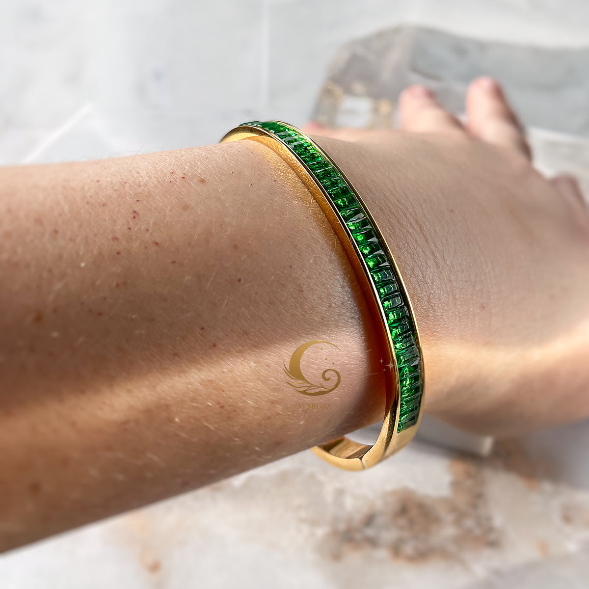 Woman wearing emerald green bangle bracelet – styled on wrist with natural light reflections, strong and confident design