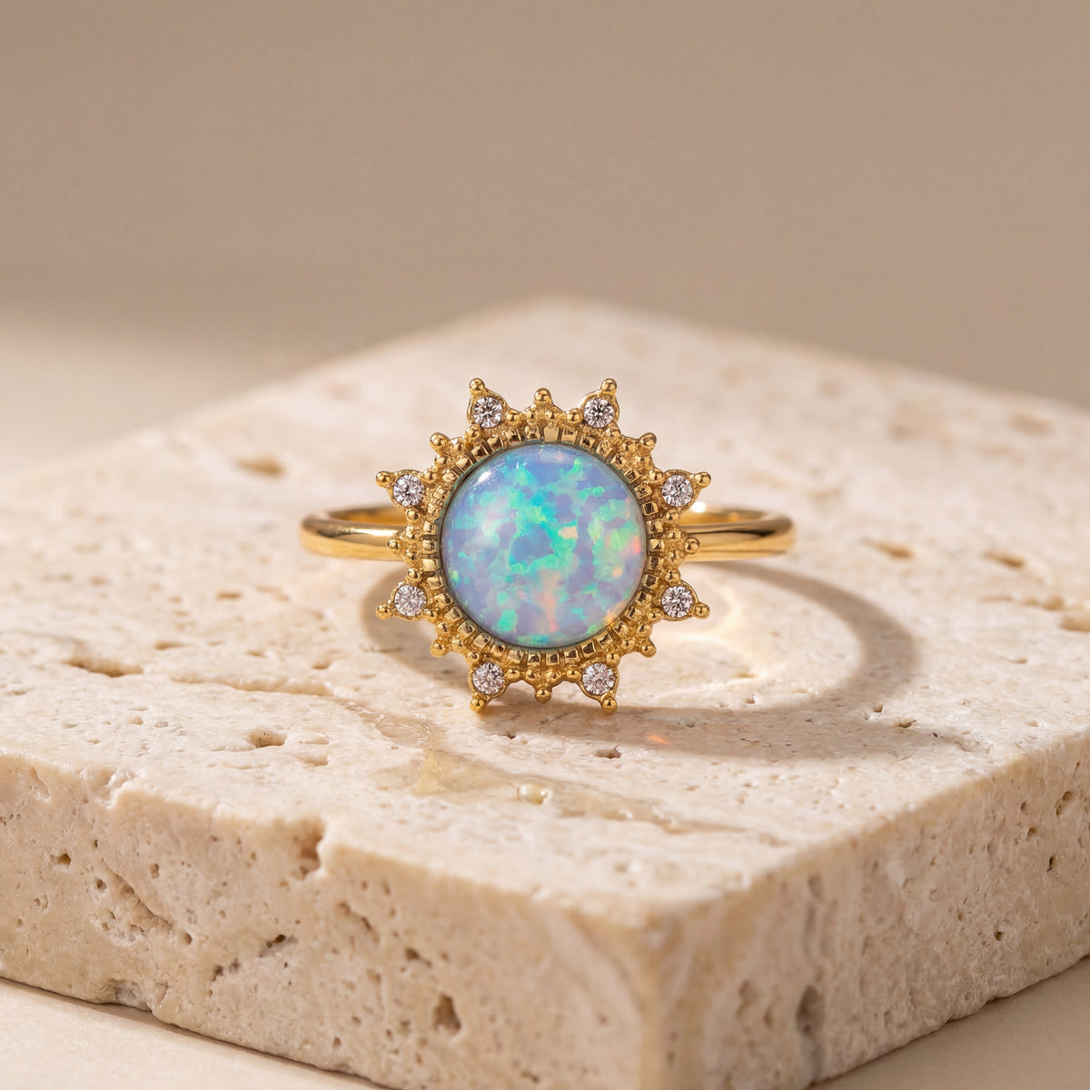 Gold ring with an opal stone on a textured surface