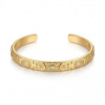 Gold bracelet with intricate designs and small diamonds on a white background