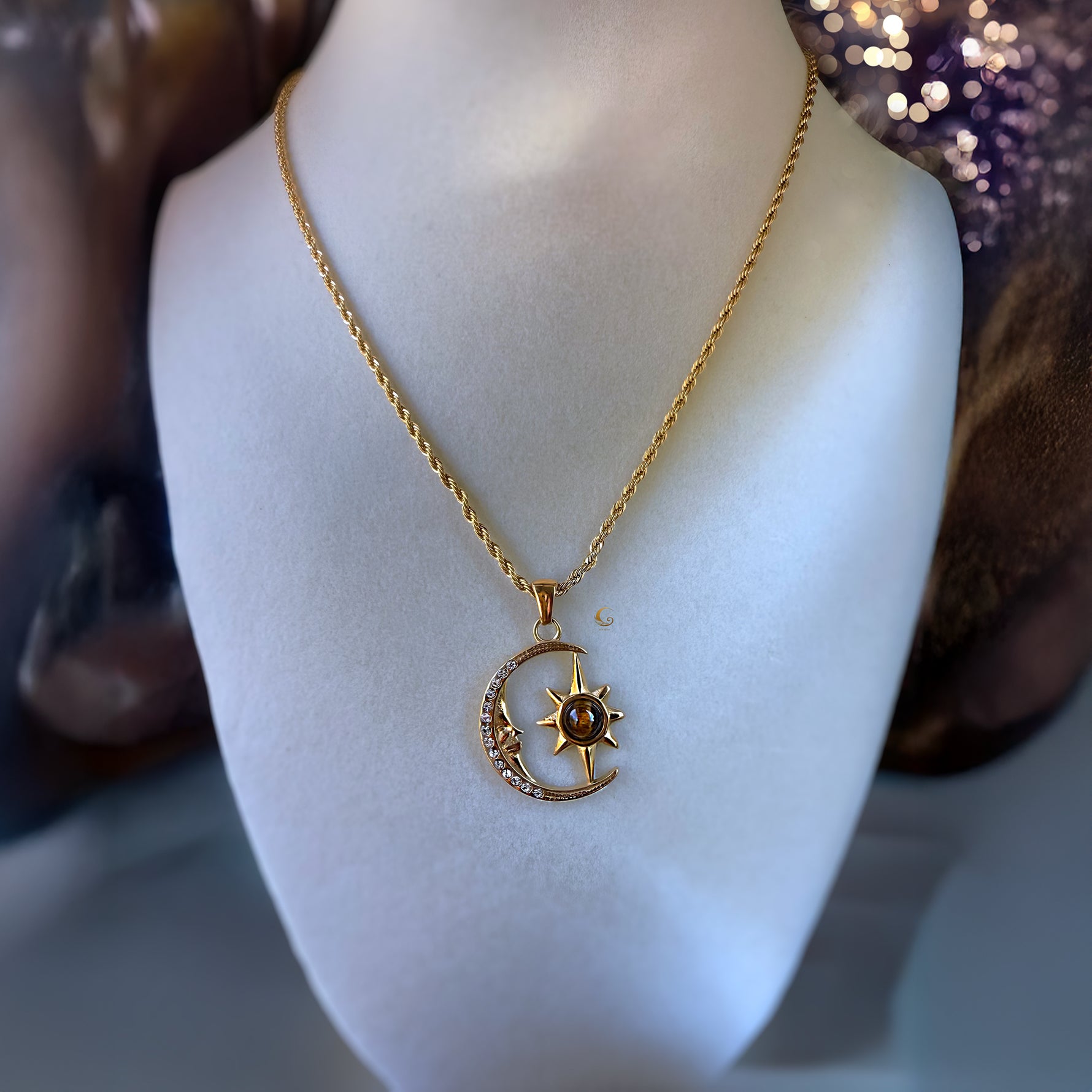 Gold necklace with a moon and star pendant on a mannequin bust.