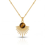Gold necklace with a sunburst pendant featuring a brown gemstone on a white background