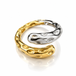 A two-tone metallic ring with a textured, organic bubble-like surface, featuring one half in polished yellow gold and the other in polished silver, set against a clean white background with a soft reflection.