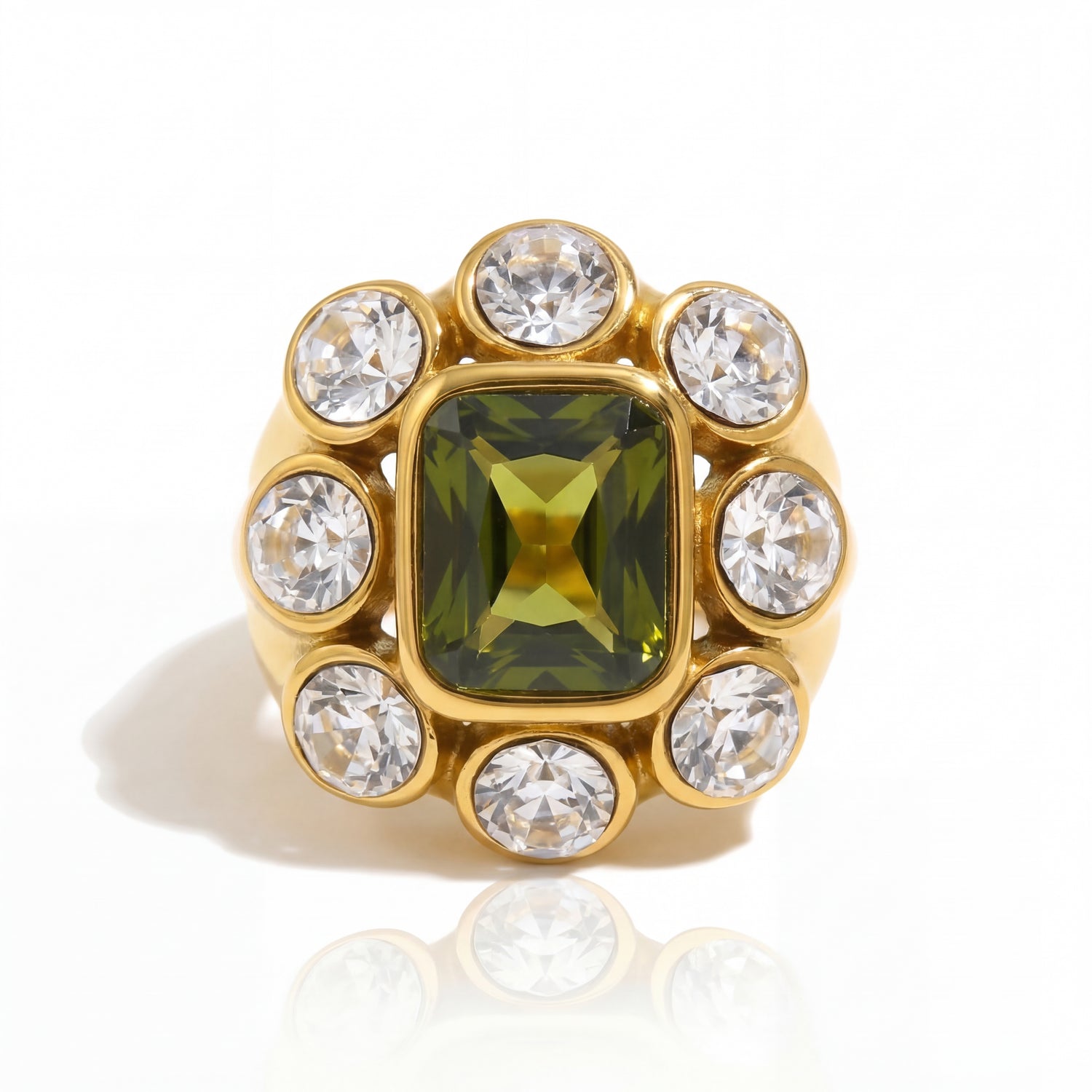Gold ring with a green gemstone and clear crystals on a white background