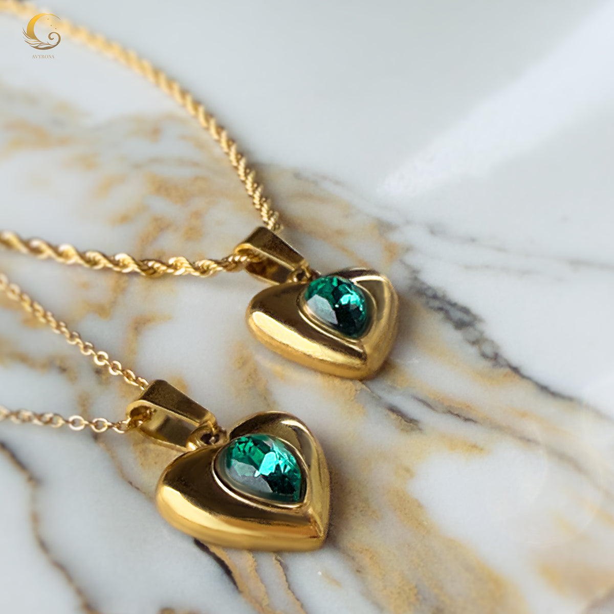 Green crystal heart pendants on marble surface, showing their elegant shimmer