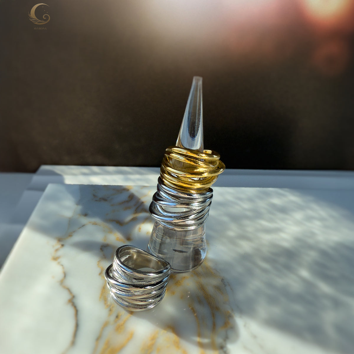 Display of Branch Rings on a clear ring stand, with light casting gentle shadows to emphasize the textured finish.