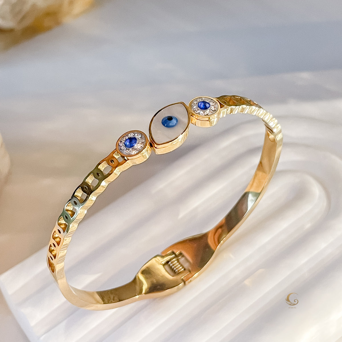 Gold bangle bracelet with Evil Eye charm and delicate openwork band, side angle