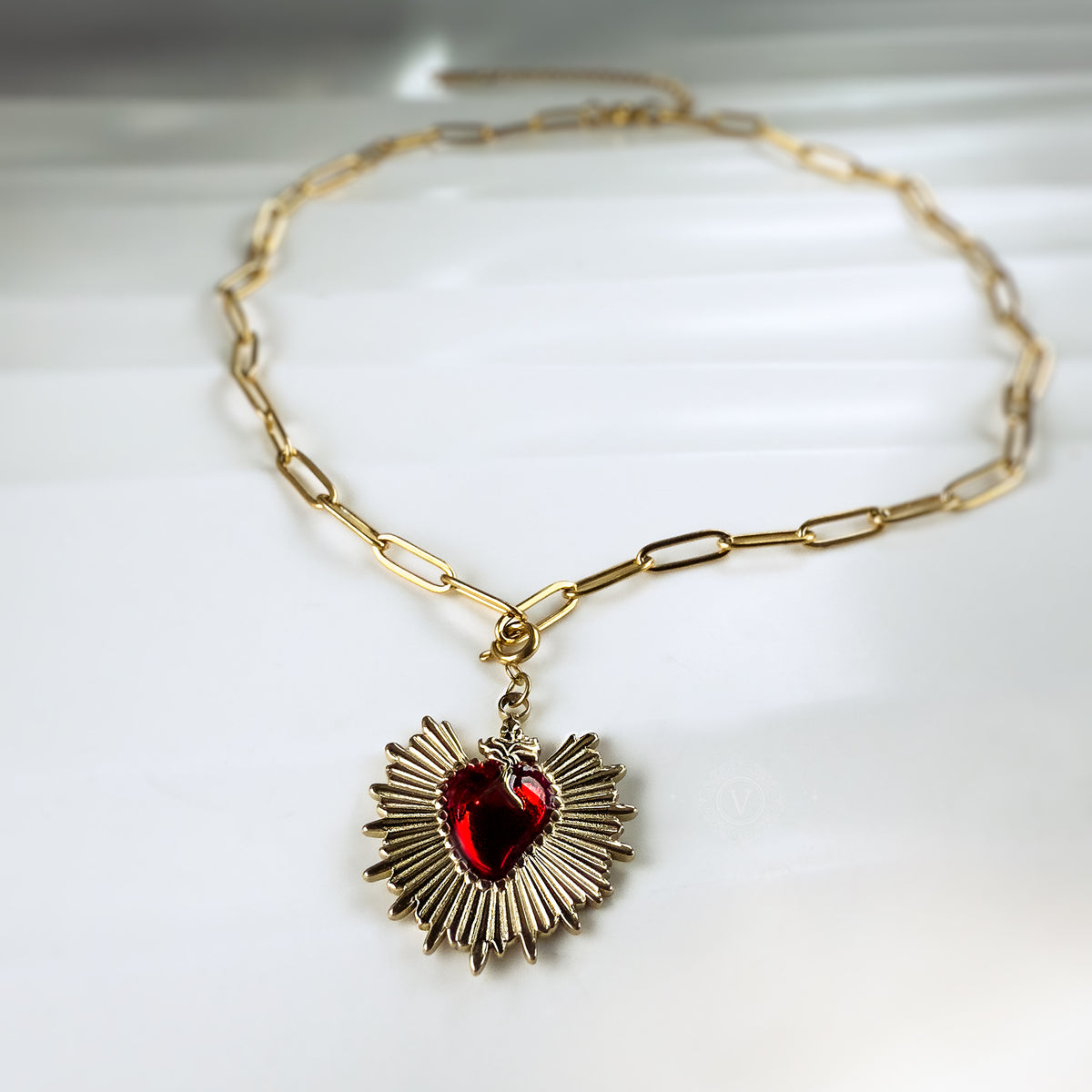 Full circular view of the Eloria necklace laid flat to show the paperclip chain and pendant from above.