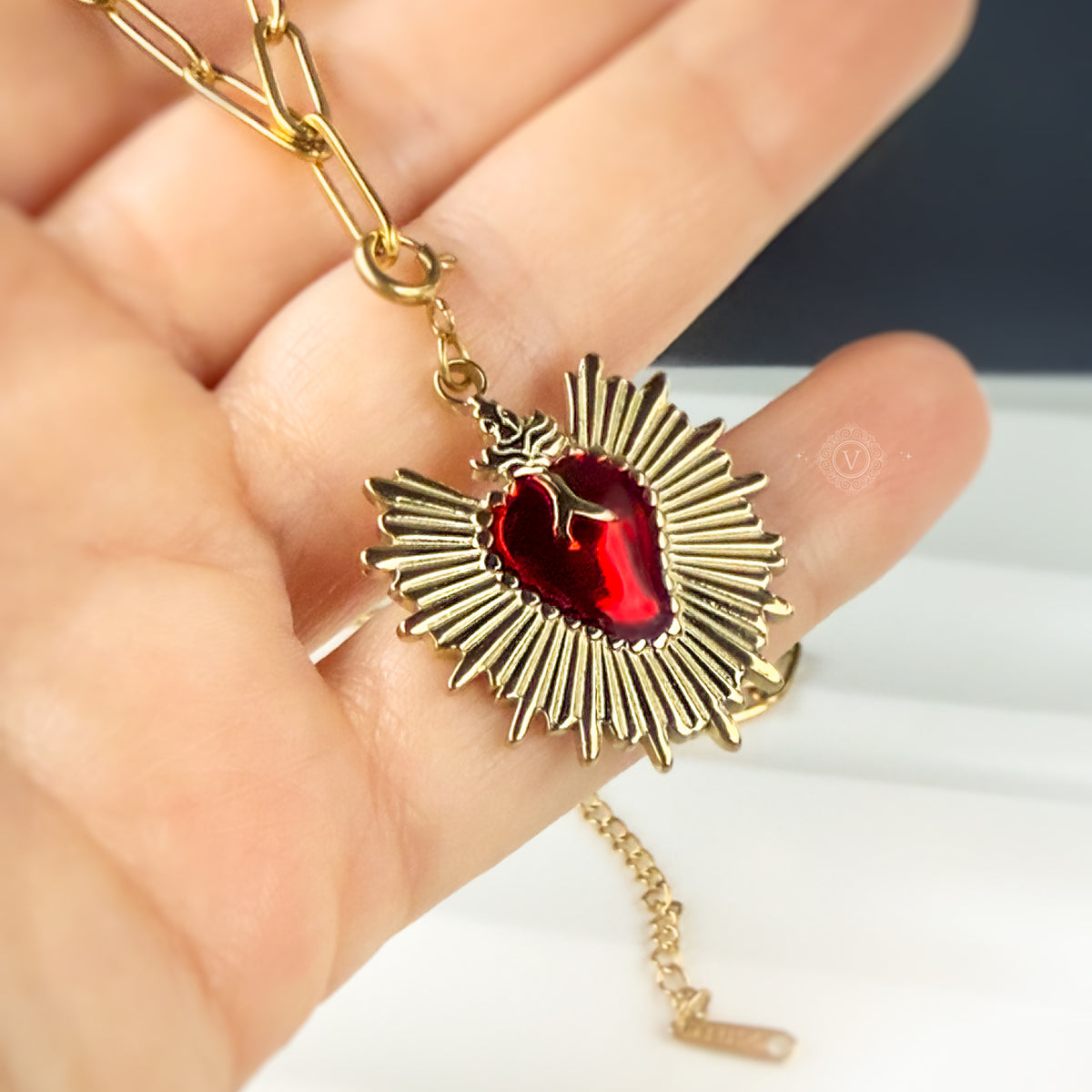 Eloria necklace shown resting on a hand, highlighting the pendant's shine and sculptural heart detail.