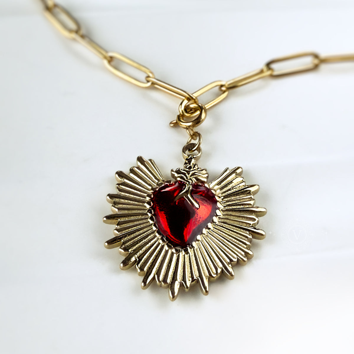  Macro front view of the Eloria pendant with detailed golden rays surrounding the red flaming heart.