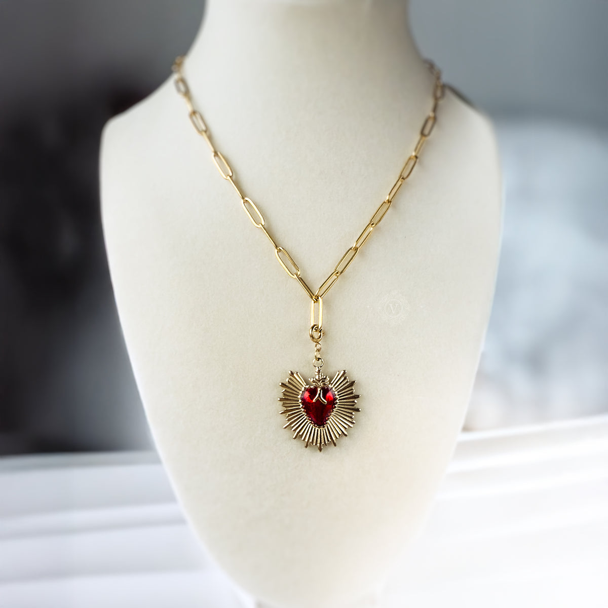 Eloria necklace displayed on a mannequin to show its length and bold Sacred Heart pendant placement.