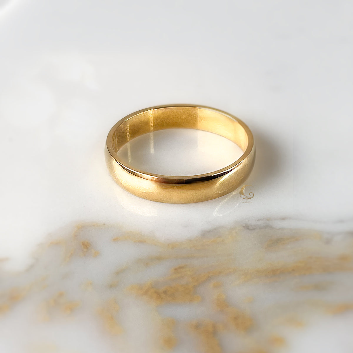  4mm gold band ring with subtle shine displayed on neutral stone.