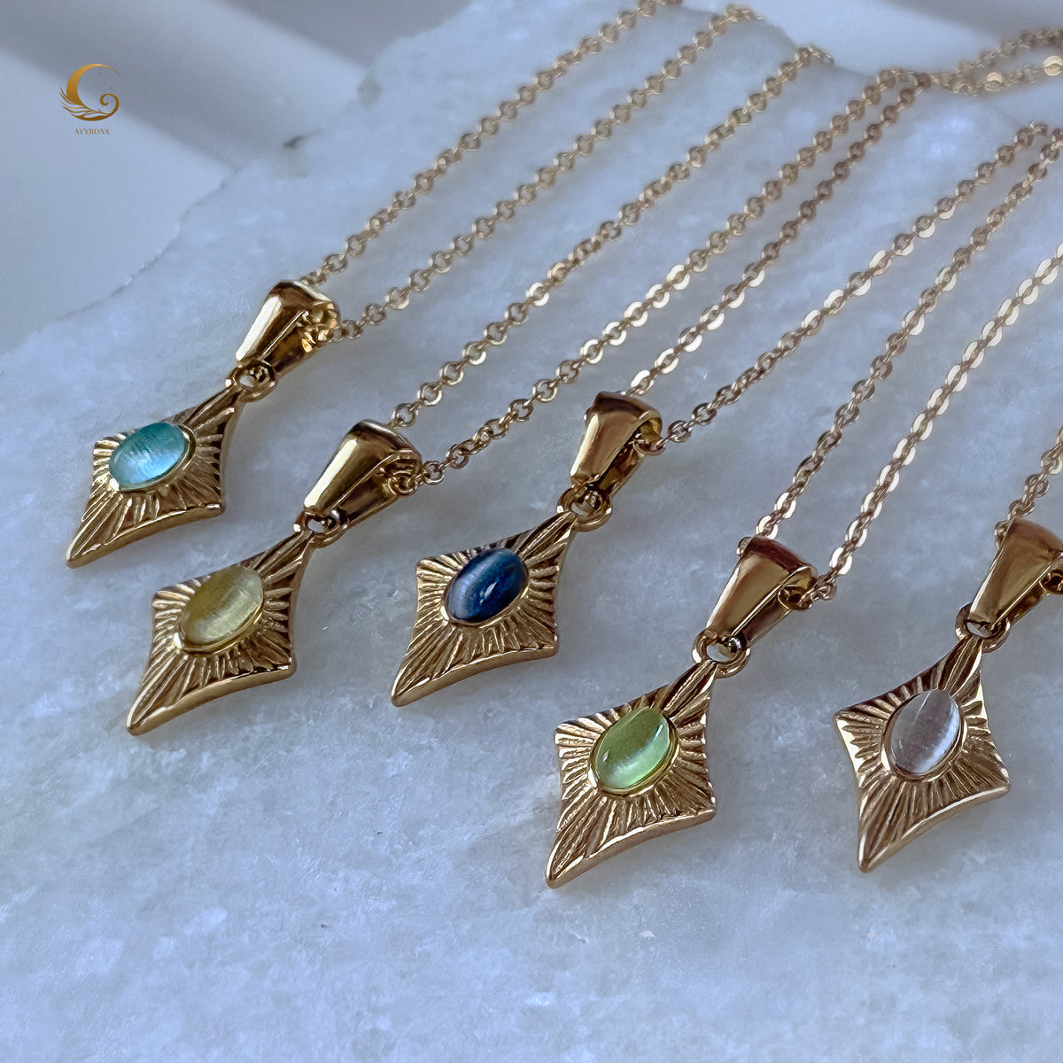 Five Guardian Amulet necklaces arranged in a row, showcasing different gemstone colors including green cat eye in the center.