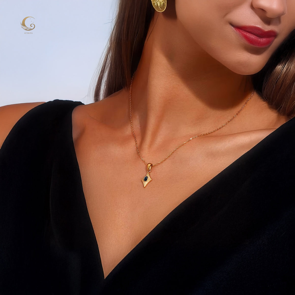 Guardian Eye necklace with black cat eye stone worn on a model with a black dress, close-up of neckline showing pendant placement.