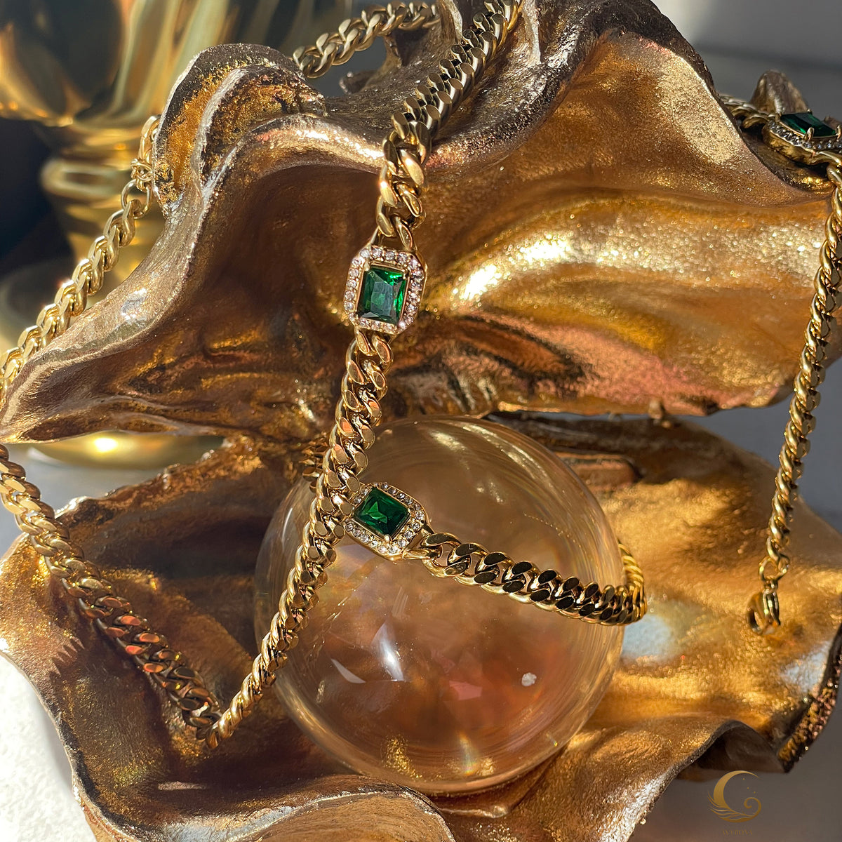 Artistic display of Harper Necklace and Bracelet wrapped around golden decor and crystal orb, creating luxurious effect.