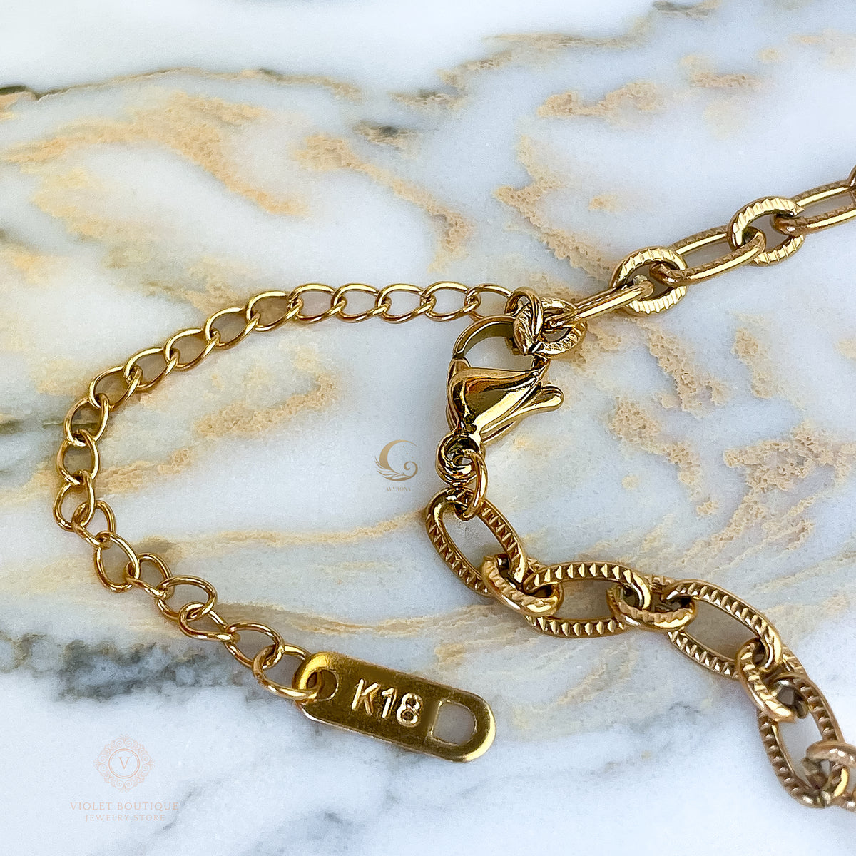 Detail of lobster clasp and extender with K18 tag on the Lyra necklace.