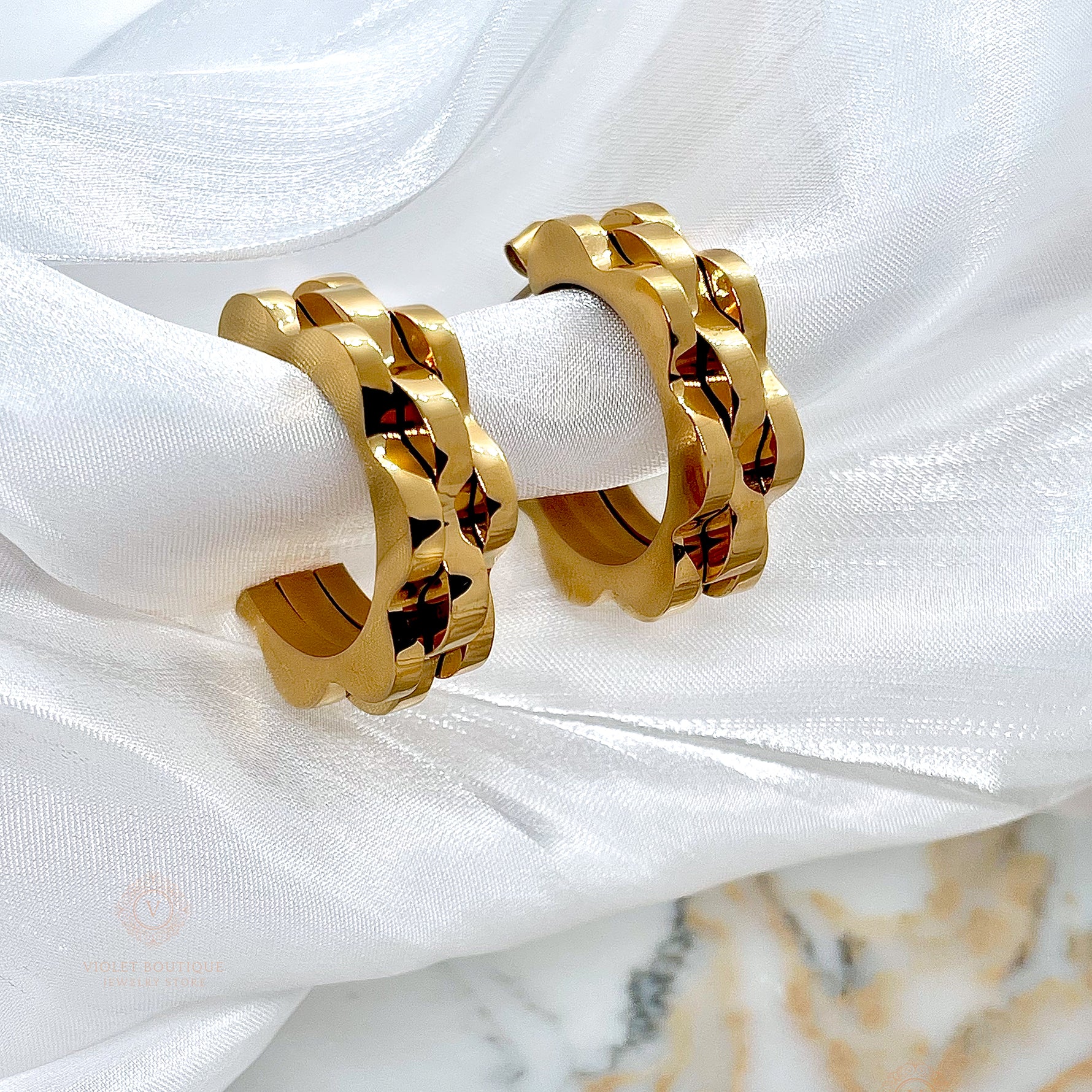 Close-up of Margaret floral petal earrings in durable stainless steel plated with rich, shiny 18K gold, styled elegantly.

