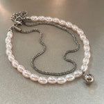Close-up view of Mimoza layered pearl bracelet showing detailed stainless steel charm and elegant double-strand vegan pearls.