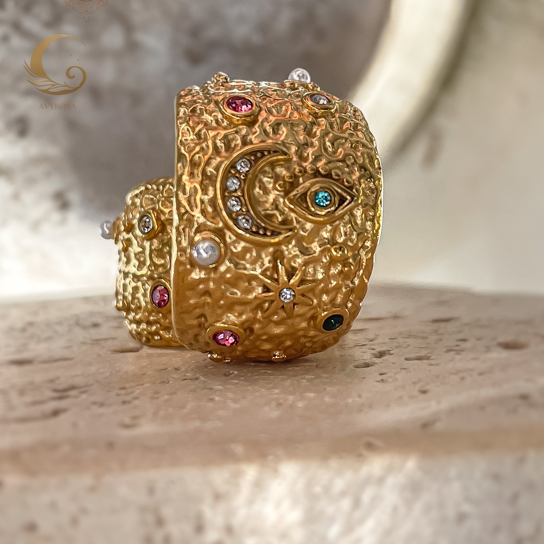 Close focus on textured moonlight earrings standing upright, highlighting crescent moon, evil eye, and star patterns in 3D relief.